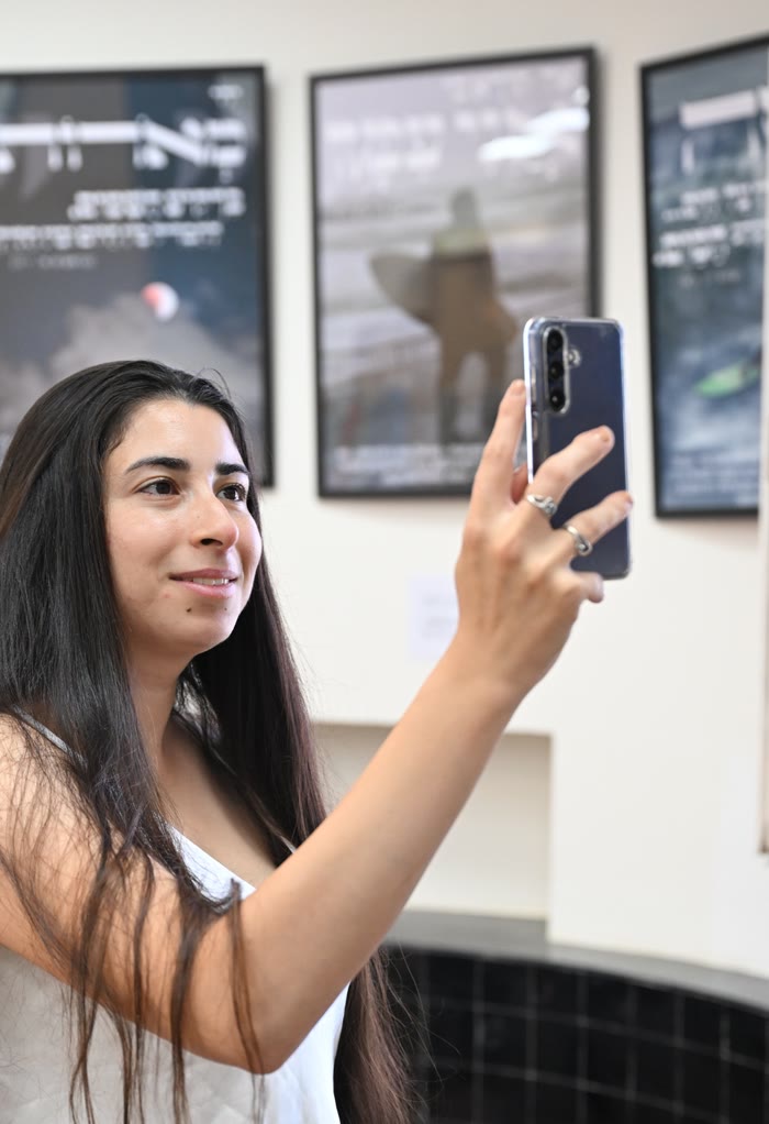 ספיר ברונזברג לוי סורקת עבודה בטלפון בתערוכה